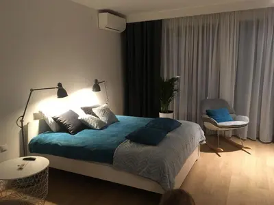 a bedroom with a bed with blue sheets and a chair at Apartment in the Gantry Hall - W19 in Kraków