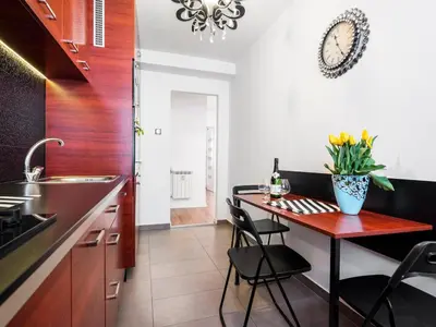 a kitchen with a table with a vase of flowers on it at Apartament Kolorowy in Kraków