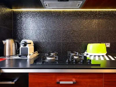 a kitchen with a stove with a yellow pot on it at Apartament Kolorowy in Kraków