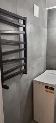 a small kitchen with a refrigerator and a window at Apartament Kolorowy in Kraków