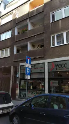 a car parked in front of a building with a parking sign at Apartament Kolorowy in Kraków