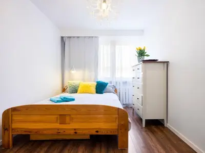 a bedroom with a wooden bed and a dresser at Apartament Kolorowy in Kraków