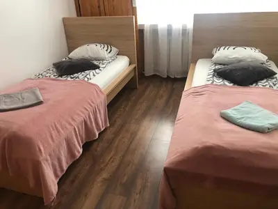two beds in a room with wooden floors at Apartament Kolorowy in Kraków