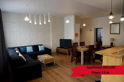 a living room with a couch and a dining room at Fogra Travel Apartment in Kraków