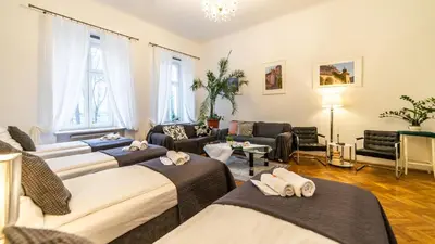 a room with three beds and a living room at Fogra Travel Apartment in Kraków