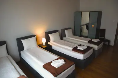 three beds in a room with a mirror at Fogra Travel Apartment in Kraków