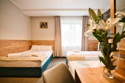 a hotel room with two beds and a table at Villa Natura Zator Przeciszów in Zator