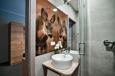 a bathroom with a sink and two deer on the wall at Villa Natura Zator Przeciszów in Zator