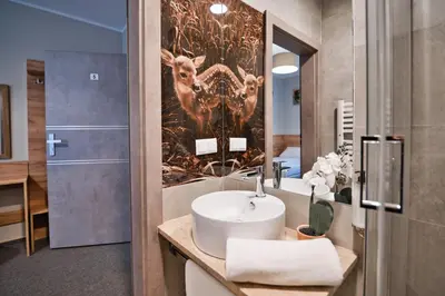 a bathroom with a sink and a wall mural of animals at Villa Natura Zator Przeciszów in Zator