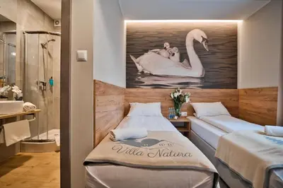 a room with two beds and a painting of a swan at Villa Natura Zator Przeciszów in Zator