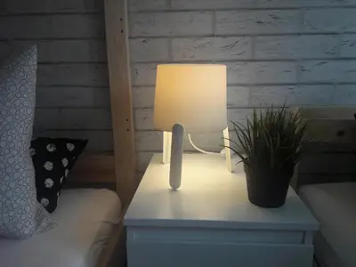 a lamp on a table next to a bed with a plant at Dobranocka - pokoje i całoroczne domki blisko Energylandii in Zator
