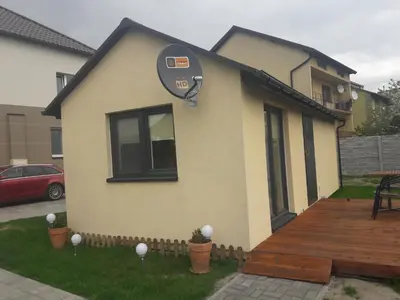 a house with a clock on the side of it at Dobranocka - pokoje i całoroczne domki blisko Energylandii in Zator