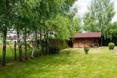 a yard with a house and trees and a fence at Charming place - Kraków Gdów Jacuzzi in Gdów