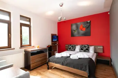 a bedroom with a red wall and a bed at Charming place - Kraków Gdów Jacuzzi in Gdów