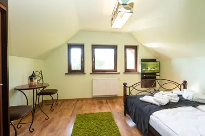 a bedroom with two beds and a table and chairs at Charming place - Kraków Gdów Jacuzzi in Gdów