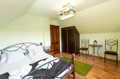 a bedroom with a bed and a table and a chair at Charming place - Kraków Gdów Jacuzzi in Gdów