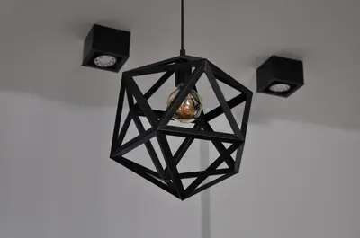 a black pendant light hanging from a white wall at Bridge Apartments 6 in Kraków