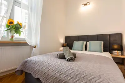 a bedroom with a large bed with two pillows on it at Bridge Apartments 6 in Kraków