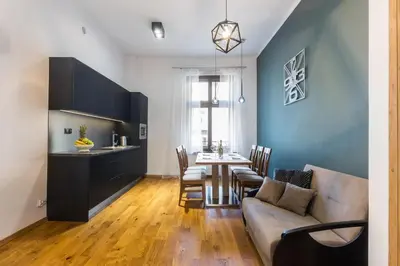 a living room with a couch and a table with chairs at Bridge Apartments 6 in Kraków