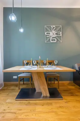 a wooden table with wine glasses on it in a room at Bridge Apartments 6 in Kraków