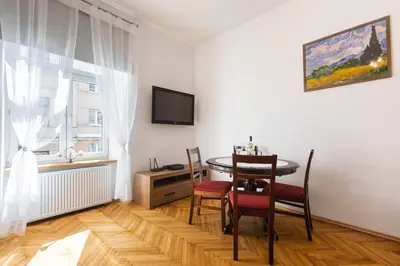 a dining room with a table and chairs and a window at Bridge Apartments 6 in Kraków