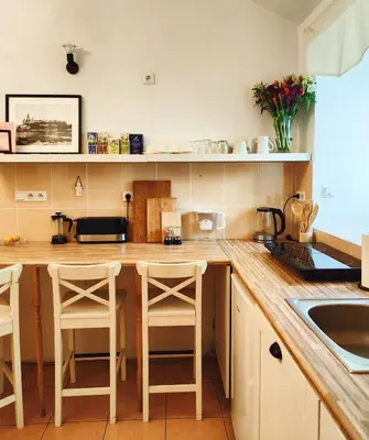 a kitchen with a wooden counter top and stools at A&K Apartment in Kraków