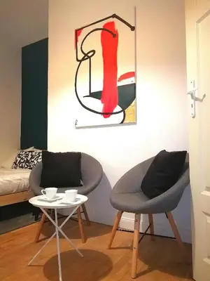 two chairs and a table in a room with a painting at A&K Apartment in Kraków