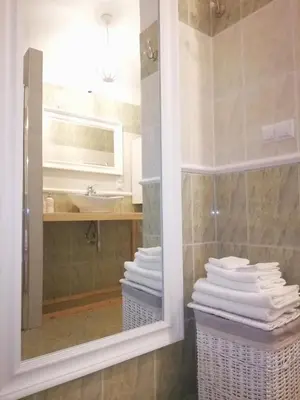 a bathroom with a mirror and a sink and towels at A&K Apartment in Kraków