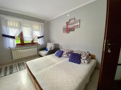 a bedroom with a bed and a television on a wall at Noclegi u Marii - Koninki in Poręba Wielka