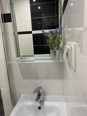 a bathroom sink with a mirror and a vase of flowers at Noclegi u Marii - Koninki in Poręba Wielka