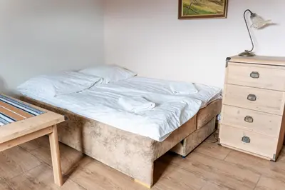 a bedroom with a bed and a dresser and a lamp at Stanica Hucuł in Sułkowice