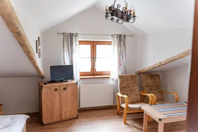a living room with a tv and a chair at Stanica Hucuł in Sułkowice
