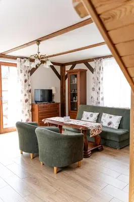 a living room with a couch and a table and chairs at Stanica Hucuł in Sułkowice