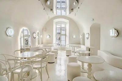 a room with white tables and chairs and mirrors at Draggo House Rooms - Old Town in Kraków