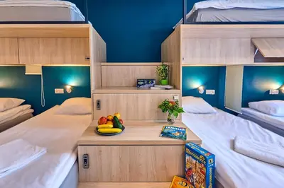 a room with two bunk beds with a bowl of fruit on a table at Draggo House Rooms - Old Town in Kraków