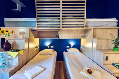two beds in a room with blue walls at Draggo House Rooms - Old Town in Kraków