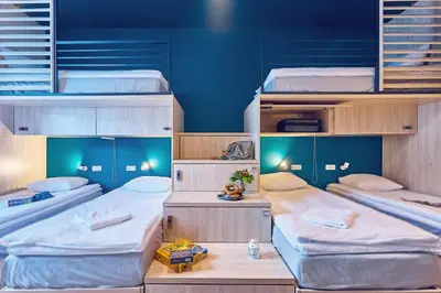 a room with three bunk beds with blue walls at Draggo House Rooms - Old Town in Kraków