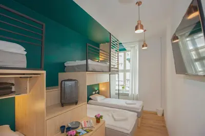 a room with two bunk beds and a tv at Draggo House Rooms - Old Town in Kraków