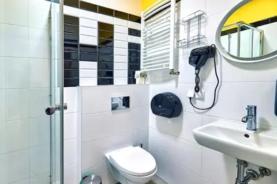 a bathroom with a toilet and a sink and a mirror at Draggo House Rooms - Old Town in Kraków