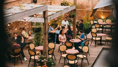 a group of people sitting at tables in a restaurant at Draggo House Rooms - Old Town in Kraków
