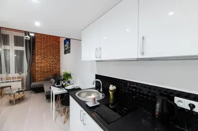 a kitchen with a sink and a living room at DIETLA 99 APARTMENTS - IDEAL LOCATION - in the heart of Krakow in Kraków