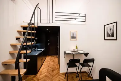 a room with a staircase and a table and chairs at DIETLA 99 APARTMENTS - IDEAL LOCATION - in the heart of Krakow in Kraków