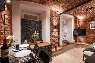 a room with a brick wall and a table and chairs at DIETLA 99 APARTMENTS - IDEAL LOCATION - in the heart of Krakow in Kraków