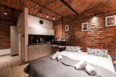 a brick walled room with a bed and a kitchen at DIETLA 99 APARTMENTS - IDEAL LOCATION - in the heart of Krakow in Kraków