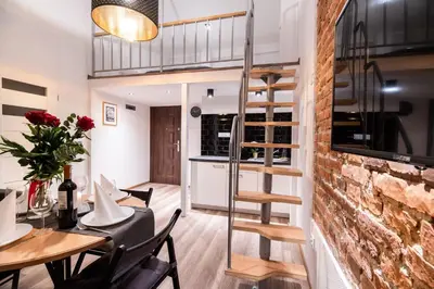 a kitchen and dining room with a spiral staircase in a tiny house at DIETLA 99 APARTMENTS - IDEAL LOCATION - in the heart of Krakow in Kraków