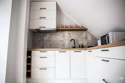 a kitchen with white cabinets and a microwave at Domek u Mai in Zator