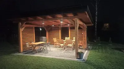 a wooden deck with a table and chairs on the grass at Domek u Mai in Zator