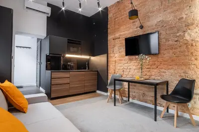 a living room with a brick wall and a table and chairs at Apartments Floriańska 24 by MB Apartments in Kraków