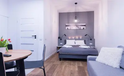 a bedroom with a bed and a table and a couch at Apartments Floriańska 24 by MB Apartments in Kraków