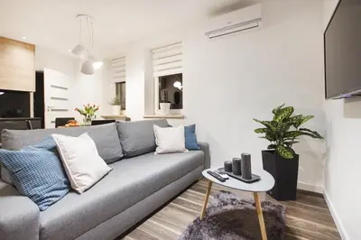 a living room with a gray couch and a table at Apartments Floriańska 24 by MB Apartments in Kraków